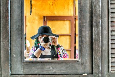 Girl on wooden window sill take photos