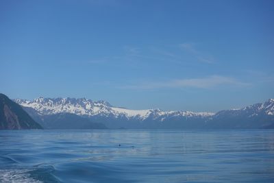 Scenic view of snowcapped mountains by sea against sky