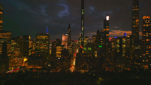 Illuminated cityscape against sky at night