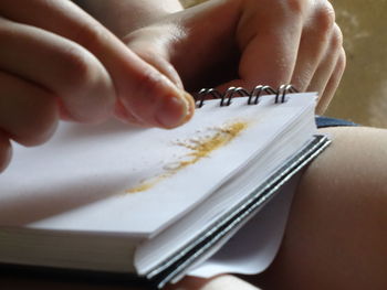 Close-up of hand holding powder on book