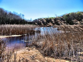 Water splashing in pond against clear blue sky