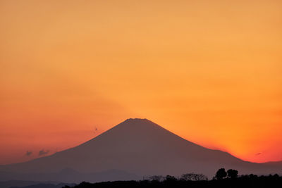 Scenic view of silhouette mountains against romantic sky at sunset