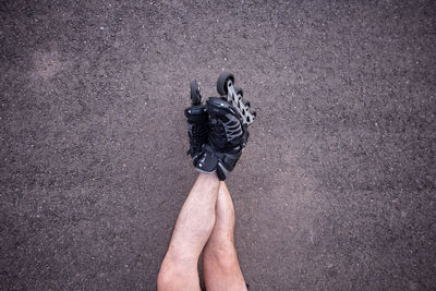 Low section of man wearing roller skate on road