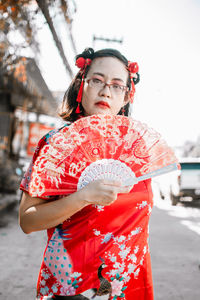 Portrait of young woman standing against sky