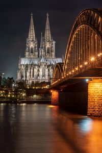 Illuminated arch bridge over river at night