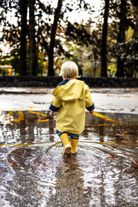 Rear view of boy running in lake