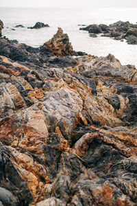 Rock formation on beach against sky