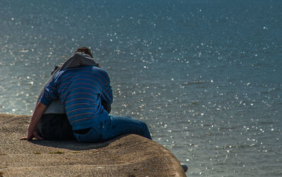 Rear view of a woman sitting on beach