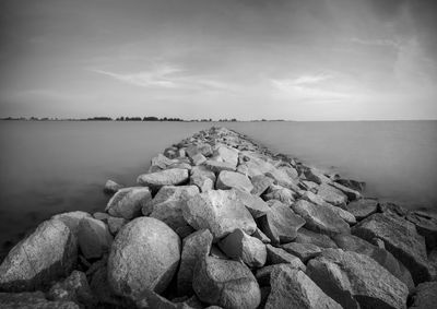 Rocks in sea against sky