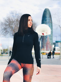 Full length of woman standing against city in background