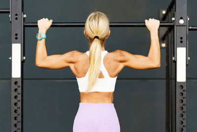 Full length of young woman exercising in gym