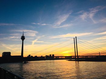 Silhouette of bridge over river against sky during sunset