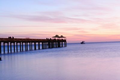 Pier over sea against sky during sunset