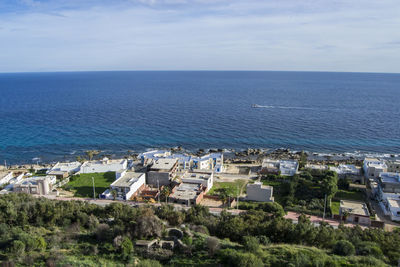 High angle view of houses by sea against sky