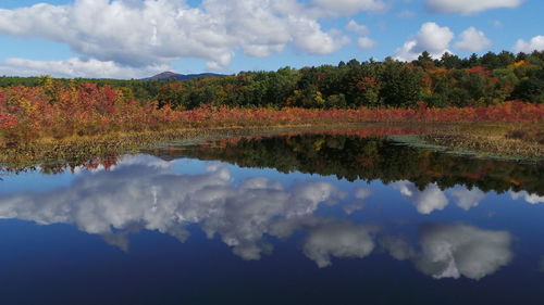 Reflection of clouds in calm lake against cloudy sky