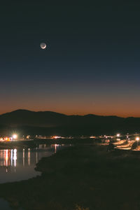 Scenic view of lake against sky at night