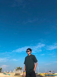 Rear view of man standing against blue sky