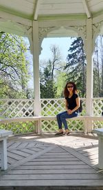 Portrait of woman sitting on seat in gazebo