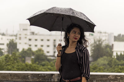 Portrait of woman standing on rainy day