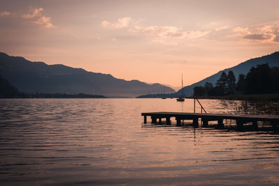 Scenic view of lake and mountains against sky during sunset