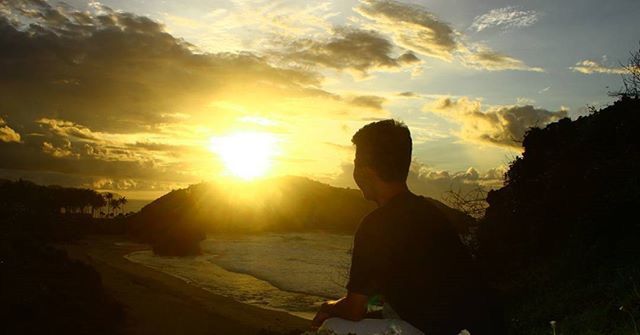 sunset, sun, lifestyles, leisure activity, sky, silhouette, sunlight, beauty in nature, standing, nature, sunbeam, tranquility, three quarter length, rear view, cloud - sky, tranquil scene, scenics, lens flare