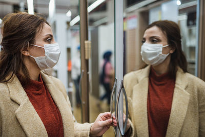 Woman wearing mask looking at cupboard