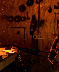 Midsection of man holding illuminated lighting equipment