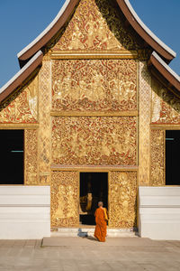 Rear view of man outside temple against building