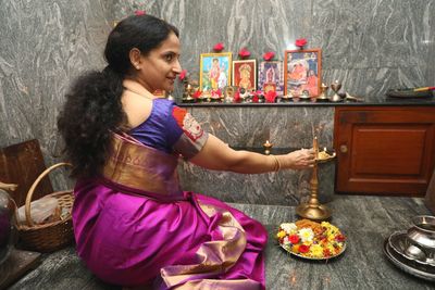 Rear view of woman worshiping at temple