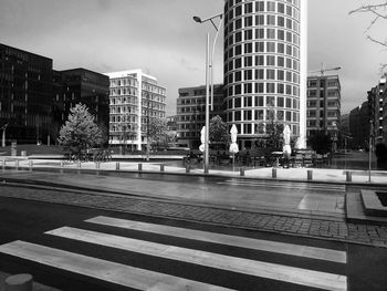 Empty road against built structures