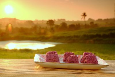 Close-up of dessert on table against sky during sunset