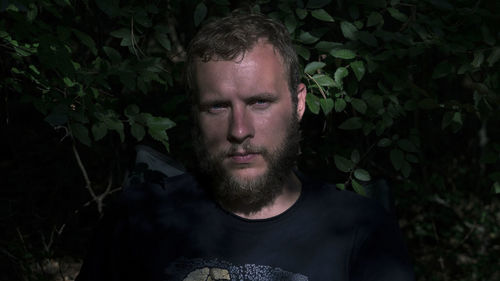 Portrait of young man with green leaves