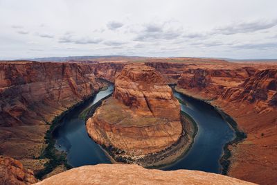 Scenic view of horseshoe bend by river against sky