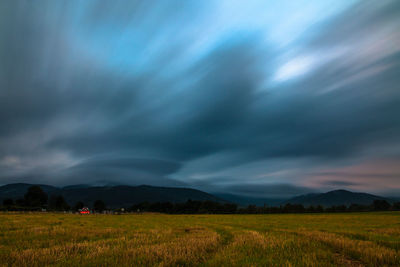 Scenic view of agricultural field against dramatic sky