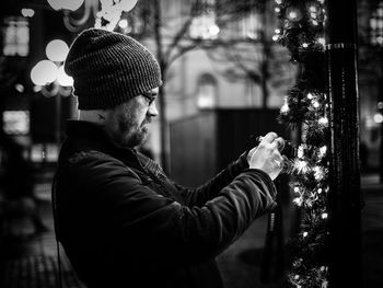 Man decorating during christmas at night