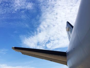 Low angle view of airplane wing against sky