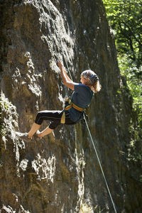 Rear view of man climbing on rock