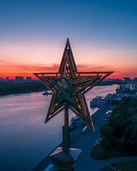 Illuminated sculpture against sky at dusk