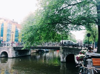 Bridge over river in city against sky