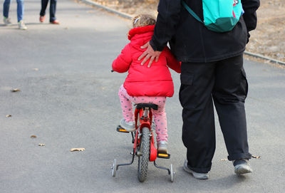 Low section of people with bicycle on road