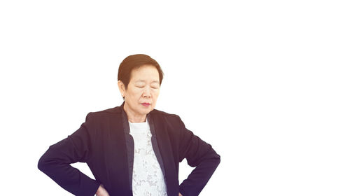 Portrait of young man standing against white background