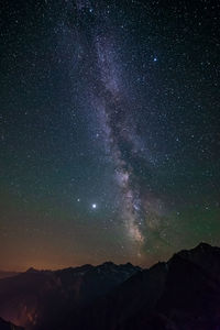 Scenic view of mountains against sky at night