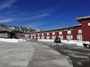 Road by buildings against blue sky during winter