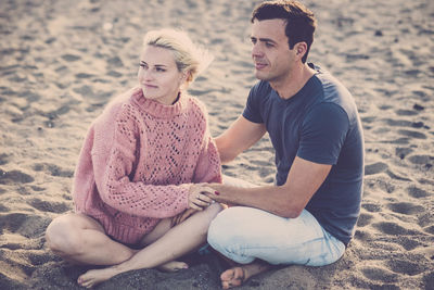 Young couple sitting on beach