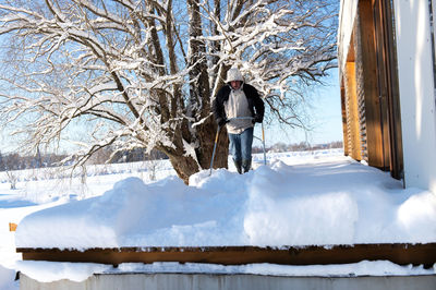 Rear view of woman standing on snow covered field