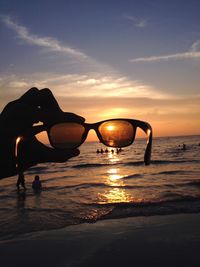 Silhouette man at beach against sky during sunset