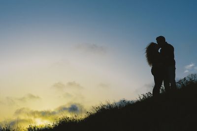 Silhouette people standing against sky during sunset