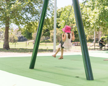 Girl playing on swing at park