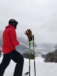 Man standing on snow covered mountain against sky