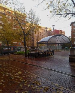 Street amidst buildings against sky during autumn